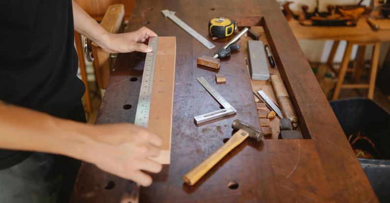 Hammer Control - Man working with wood and ruler in carpentry studio