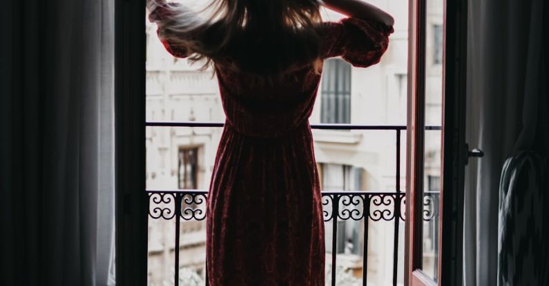Forge - Unrecognizable woman touching hair and looking out balcony