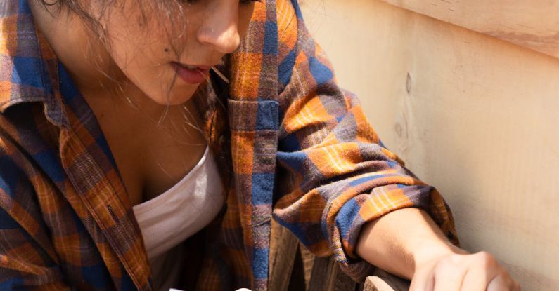 Hammering - Woman hammering a Nail to a Wood Plank